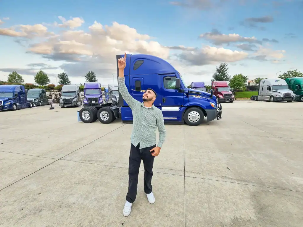 Truck driver in front of used semi trucks from pedigree truck and trailer sales.